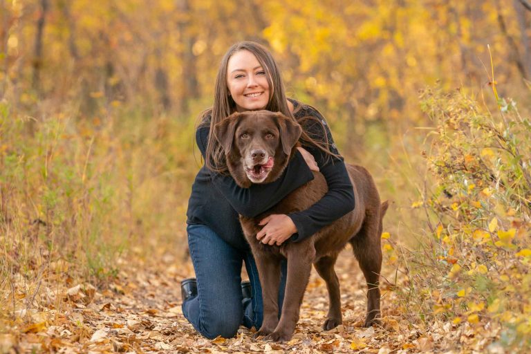 dog mom hugging her labrador dog around the neck, photographed in Carburn park, Calgary, AB