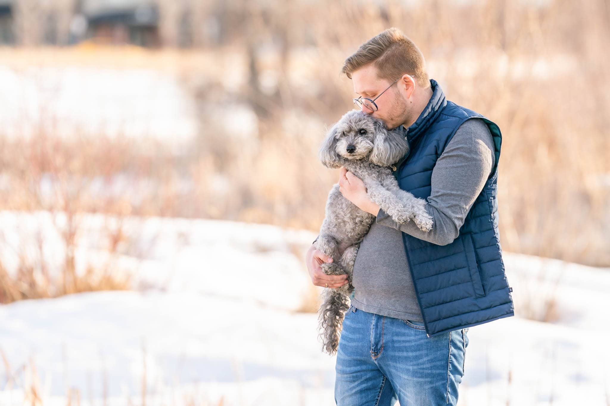 Calgary man holding and kissing his dog.